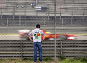 A TV crew member watches Ferrari driver